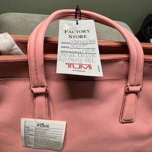 Pink Tumi purse, multiple pockets and compartments. Never been used.